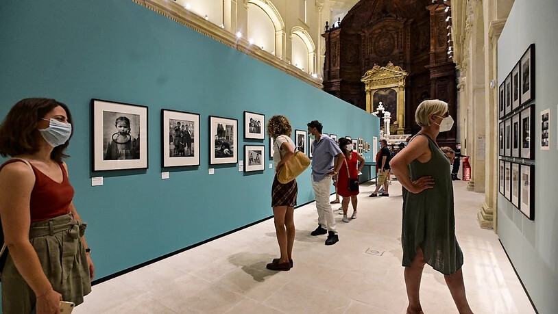 Besucher betrachten Fotografien in der Ausstellung der schweizerisch-französischen Fotografin Sabina Weiss auf dem Fotografie-Weltfestival. Foto: Vondrou? Roman/CTK/dpa