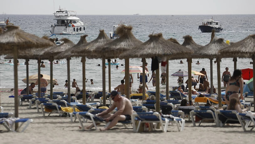Gäste liegen am Strand von Paguera auf Mallorca. Nach der angekündigten Hochstufung Spaniens zum Corona-Hochinzidenzgebiet gibt es zunächst keine Hinweise, dass viele Menschen ihren Urlaub vorzeitig abbrechen oder gebuchte Aufenthalte stornieren wollen…