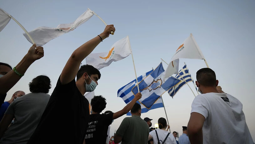 Bewohner der verlassenen Stadt Varosha oder Famagusta halten zypriotische und griechische Fahnen während eines Protestes gegen die türkische Regierung. Die Europäische Union droht der Türkei wegen der jüngsten Eskalation des Zypernkonflikts mit…