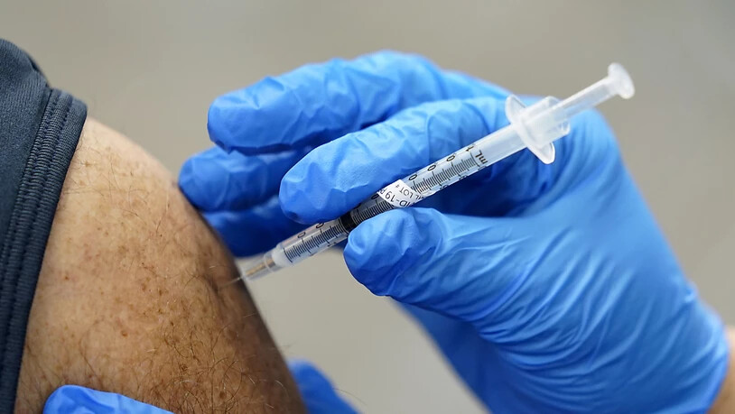 ARCHIV - Ein Mitarbeiter des Gesundheitswesens wird ein zweites Mal mit dem Impfstoff von Pfizer/Biontech geimpft. Angesichts der rasch steigenden Zahl neuer Corona-Infektionen haben sich in den USA zuletzt wieder deutlich mehr Menschen impfen lassen…