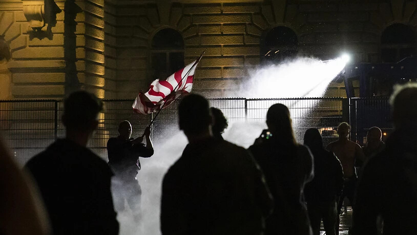 Die Polizei setzt den Wasserwerfer gegen die Demonstranten auf dem Bundesplatz ein.