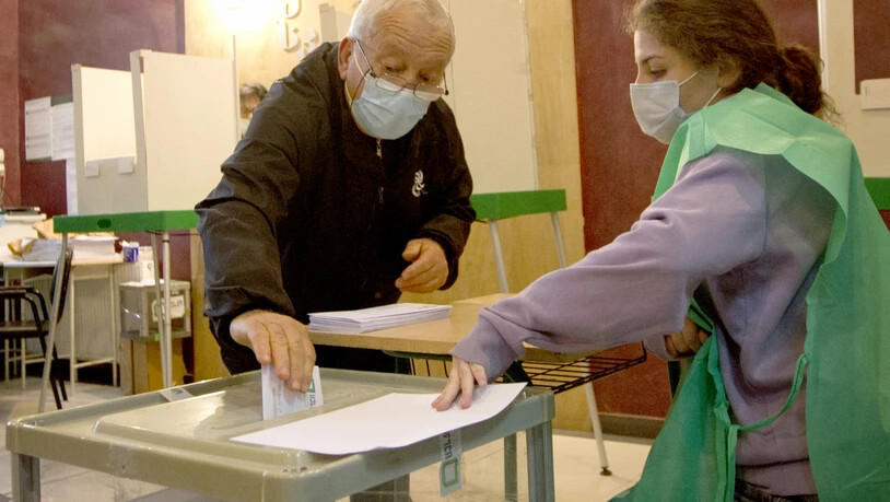 Ein Mann wirft seinen Stimmzettel in eine Wahlurne in einem Wahllokal während der Kommunalwahlen. In der Südkaukasus-Republik Georgien wächst nach der Festnahme des früheren Präsidenten M. Saakaschwili die Sorge vor neuen innenpolitischen Spannungen…