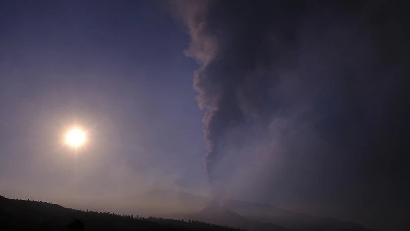 Rauch steigt am Horizont auf, während Lava aus einem Vulkan auf La Palma fließt. Auch die dortige Tourismusbranche leidet unter dem Vulkanausbruch auf der Kanareninsel. Foto: Daniel Roca/AP/dpa