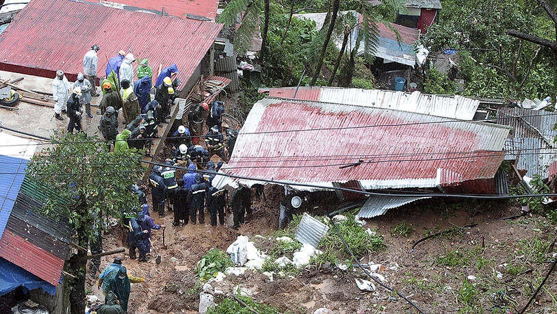 Rettungskräfte auf den Philippinen suchen in einem Haus nach Opfern. Das Haus wurde durch den Tropensturm Kompasu verursachten Erdrutsch verschüttet. Foto: Uncredited/AP/dpa