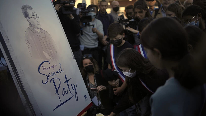 Eine Zeichnung zeigt den vor einem Jahr ermordeten Samuel Paty. Foto: Christophe Ena/AP/dpa