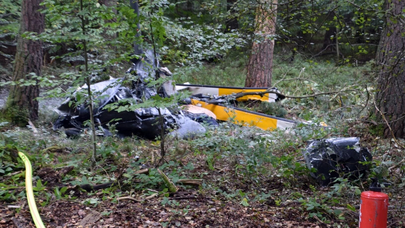Trümmerteile eines Hubschraubers liegen in einem Wald nahe der Grenze zu Hessen und Bayern. Foto: Julian Buchner/Einsatz-Report24/dpa