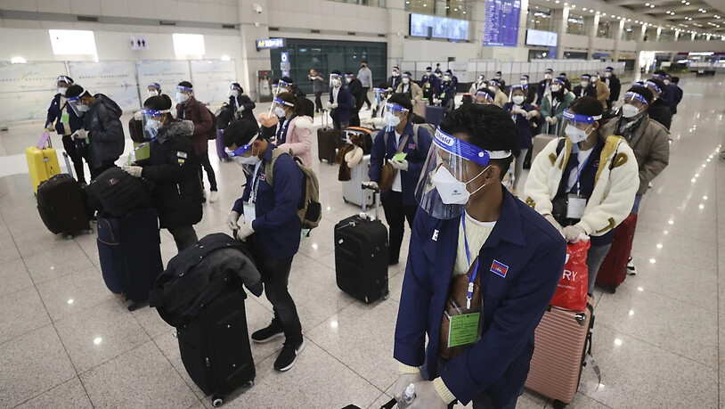 dpatopbilder - Passagiere, die aufgrund der Corona-Pandemie Mund-Nasen-Bedeckungen tragen, stehen nach ihrer Ankunft mit Abstand zueinander auf dem internationalen Flughafen Incheon. Foto: Lim Hwa-Young/Yonhap/AP/dpa