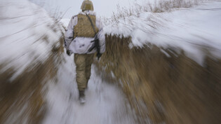dpatopbilder - Ein ukrainischer Soldat geht an der Frontlinie im Osten des Landes durch einen Graben. Foto: Vadim Ghirda/AP/dpa