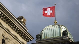 Die Schweizer Wirtschaft dürfte nach Ansicht des Internationalen Währungsfonds IWF im laufenden Jahr wieder anziehen. Der IWF rechnet für 2024 mit einem BIP-Wachstum von 1,3 Prozent. (Im Bild eine Schweizer Fahne auf dem Bundeshaus)