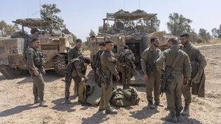 Israelische Soldaten stehen neben Mannschaftstransportern in der Nähe der Grenze zwischen Israel und Gaza, im Süden Israels. Bei den Beratungen des israelischen Kriegskabinetts sind einem Medienbericht zufolge mehrere Szenarien von Reaktionen auf den…