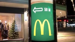 An der Bahnhofstrasse in Chur steht eine sich drehende Litfasssäule, samt Wegweiser zum nächsten McDonald's.