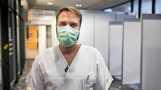 Jasper Lehmann lässt sich im Container vor dem Kantons-spital Glarus bei Alina Sengenberger und einem Kollegen auf das Coronavirus testen.  