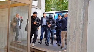 Ankunft bei Gericht: Der Angeklagte wird in Handschellen aus der Justizvollzugsanstalt zum Kreisgericht in Uznach gebracht. Dort warten Journalisten und zwei Polizisten auf ihn.