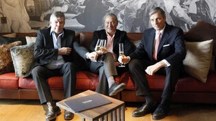 Anstossen im Luxushotel: Gérard Jenni (links) war Managing Director von Samih Sawiris (Mitte) Andermatt Swiss Alps Resort – hier sieht man ihn im Jahr 2012 bei der Präsentation des ersten Musterzimmers. 